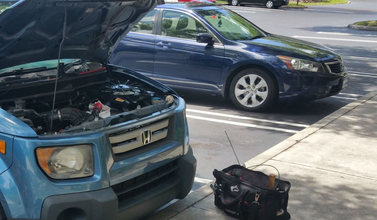 Mobile auto repair technician performing diagnostic analysis of a problem with a Honda SUV in Garden Grove, CA.