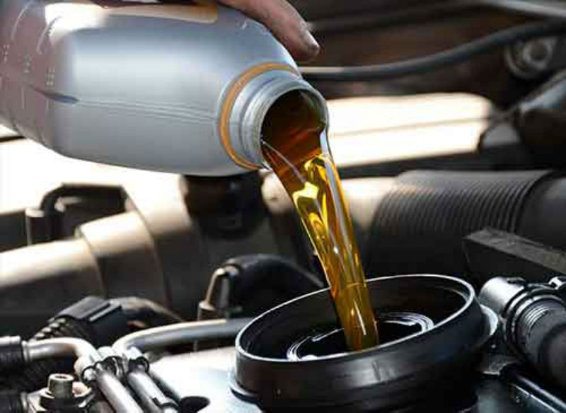 Photo of oil being poured into an automobile engine.