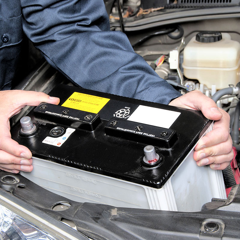 Automobile battery replacement Vehicle battery being installed to repair the electrical system.