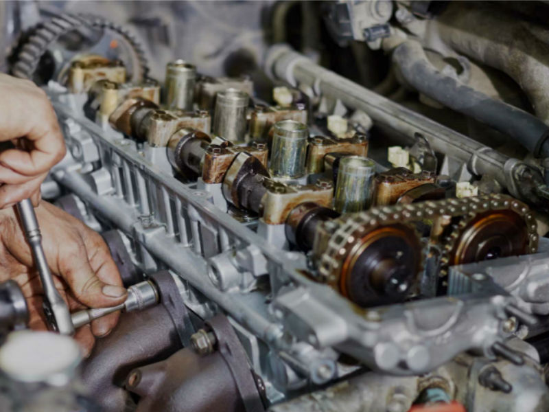 Photo of engine without valve cover showing overhead valves and exhaust manifold.