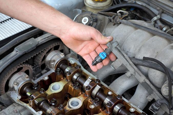 Photo of automobile fuel injector being removed.