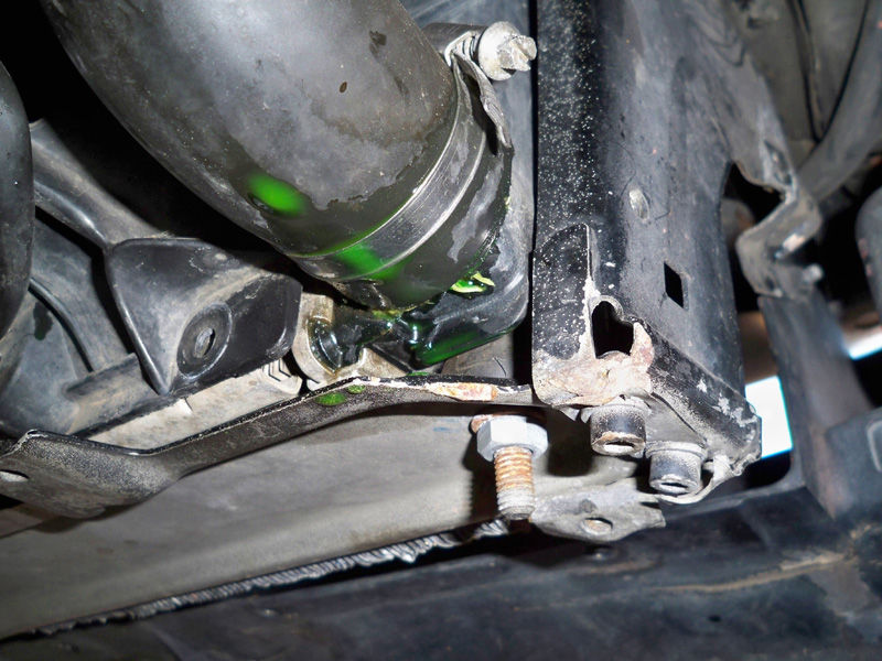 hoto of leaking lower automobile radiator hose with green coolant seeping out.