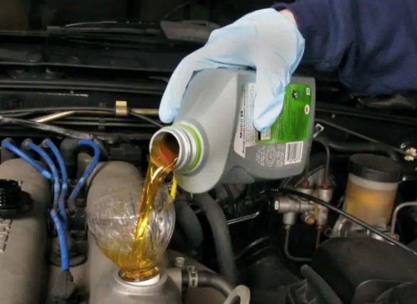 Power steering fluid change in Garden Grove. Photo of mechanic putting power steering fluid into the power steering reservoir.