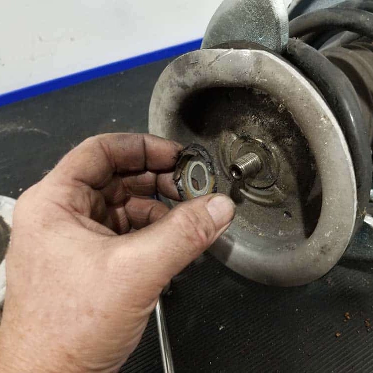 strut-replacement Photo of mechanic installing a strut on a car.